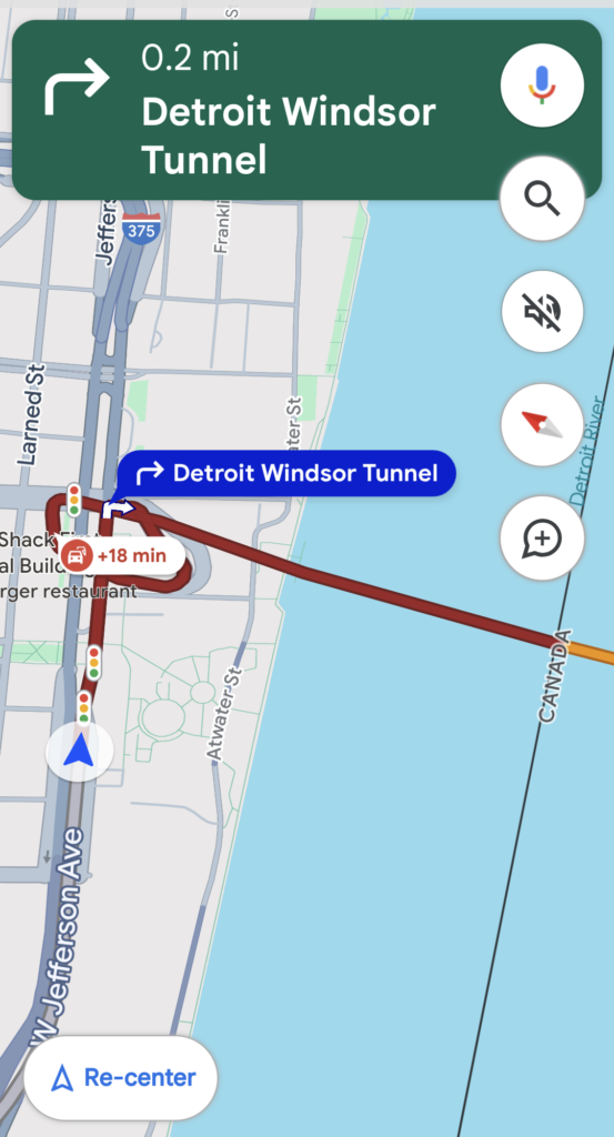 A screenshot of a phone's map application showing heavy, slow traffic en route from Detroit to Windsor via the underground tunnel.