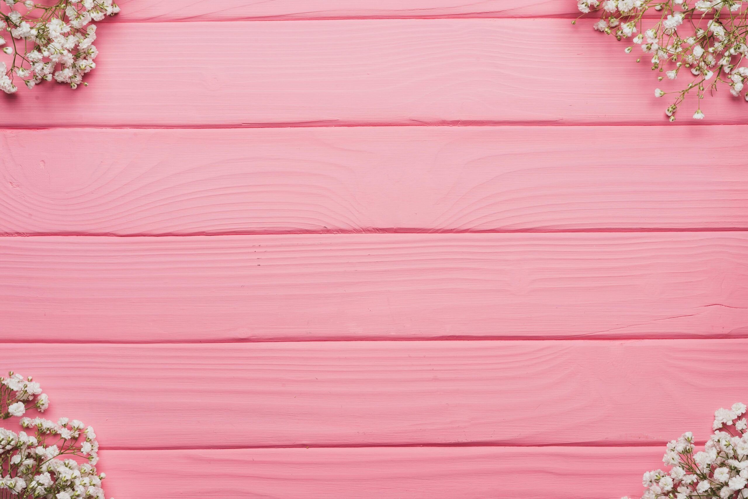 A soft pink wooden horizontal background banner with white flowers in the top and bottom corners.