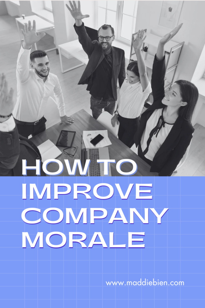 An image of men and women in a workplace at a desk, holding one arm in the air with a large smile on their face as though they were playing a game, with the text "how to improve company morale" embedded onto the image.