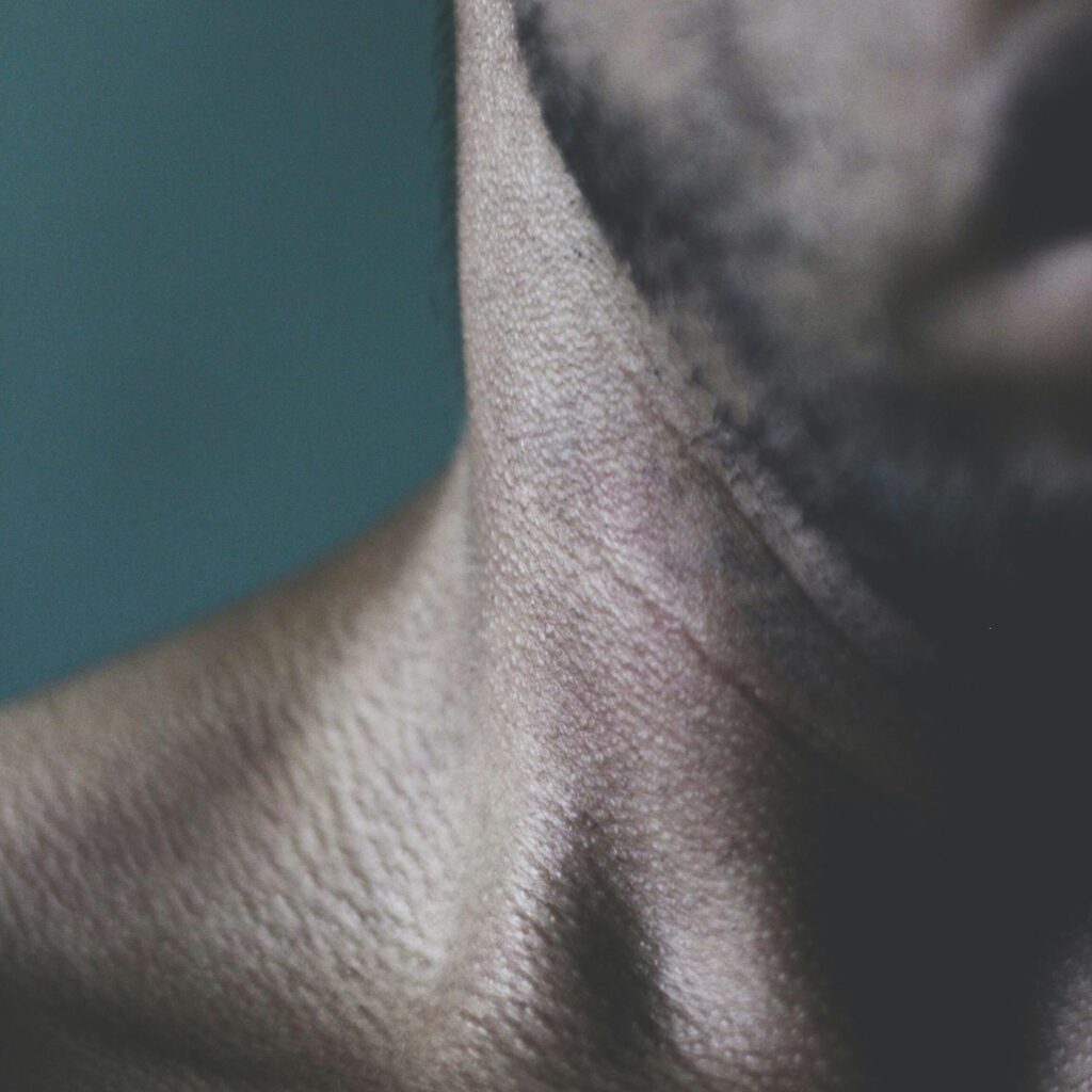 A close-up image of the base of a man's neck.